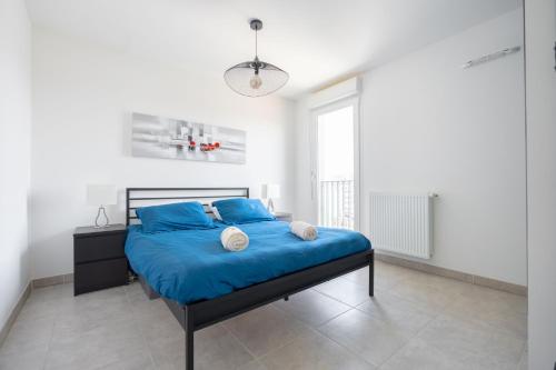 a bedroom with a blue bed in a white room at T2 Entre plage et centre ville-Terrasse/Parking in Marseille