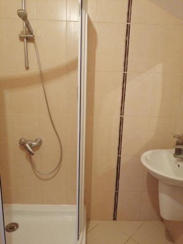 um chuveiro com uma porta de vidro ao lado de um lavatório em Апартамент в Бяла em Byala