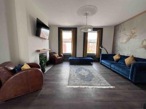 a living room with a blue couch and chairs at Marina Lodge in Gosport