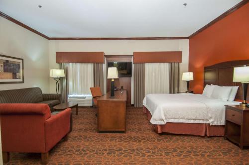 a large hotel room with a bed and a couch at Hampton Inn and Suites Waxahachie in Waxahachie