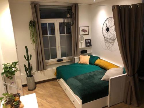 een kleine slaapkamer met een bed en een raam bij Studio Dream On in Oostende
