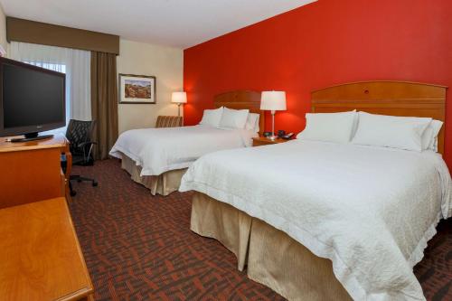 a hotel room with two beds and a flat screen tv at Hampton Inn Dayton Fairborn Wright Patterson AFB in Fairborn