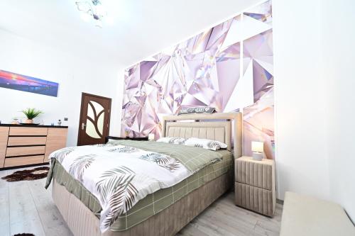 a bedroom with a bed and a geometric wall at A&N Central Apartment in Sibiu