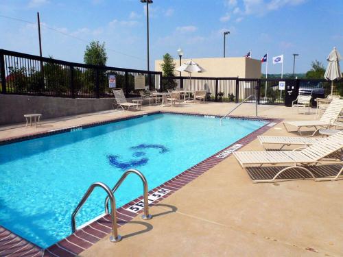 una grande piscina con sedie a sdraio, tavoli e sedie di Hampton Inn Dallas-Rockwall a Rockwall