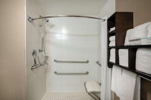 y baño con ducha y toallas blancas. en Hampton Inn Dublin, en Newbern