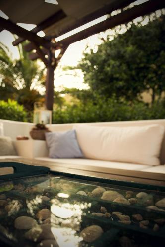 a white couch on a patio with a glass table at Vagia Traditional, Aegina Island in Vaia