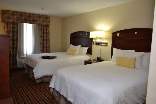 a hotel room with two beds with white sheets at Hampton Inn & Suites Dayton-Airport in Englewood