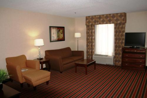 a living room with a couch chair and a television at Hampton Inn & Suites Dayton-Airport in Englewood