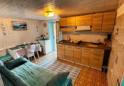 eine Küche mit einem Sofa und einem Tisch in einem Zimmer in der Unterkunft Guesthouse Porto in Cres