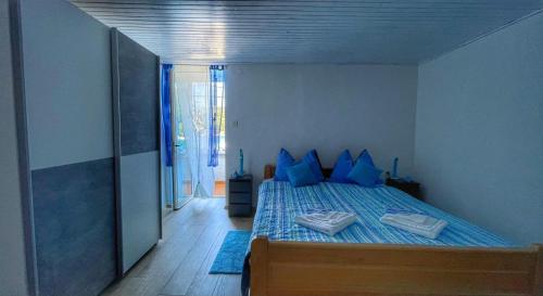 sypialnia z niebieskim łóżkiem i niebieskimi poduszkami w obiekcie Guesthouse Porto w mieście Cres