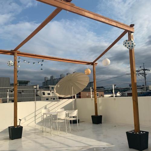 a patio with a table and chairs and an umbrella at Hostel Espace in Chuncheon