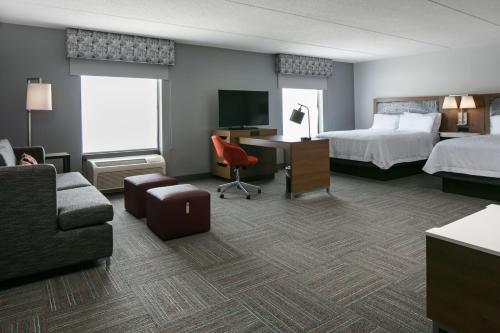 Habitación de hotel con cama, escritorio y sofá en Hampton Inn Dubuque en Dubuque