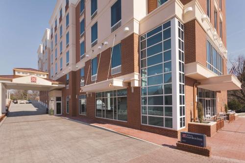 a large brick building with a sign in front of it at Hilton Garden Inn Falls Church in Falls Church