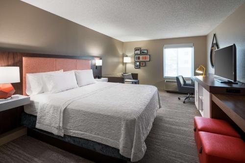 a hotel room with a bed and a television at Hampton Inn Denver-West/Golden in Golden