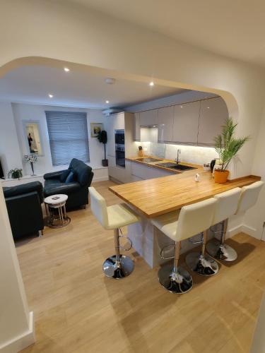 a kitchen and living room with a wooden table and chairs at No 1 Penlee in Penzance