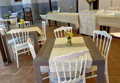 特罗佩阿La Locanda del Convento的一张桌子、白色的椅子和一张鲜花桌子