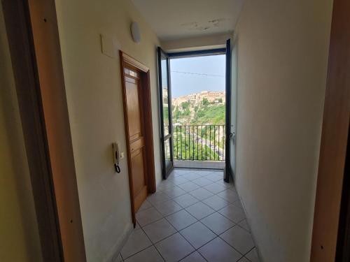 - un couloir avec une porte menant à un balcon offrant une vue dans l'établissement La Locanda del Convento, à Tropea