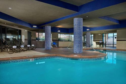 a swimming pool in a hotel with chairs and tables at Hampton Inn & Suites Denver/Highlands Ranch in Littleton