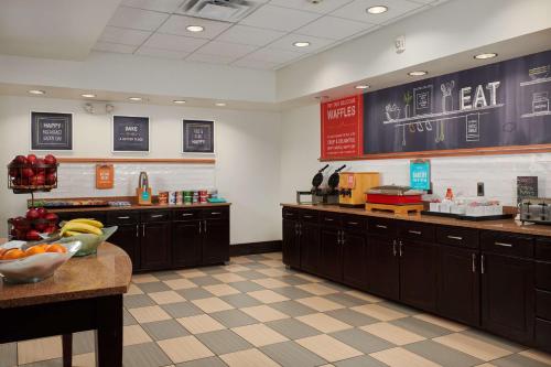 a kitchen with wooden cabinets and fruits on the counter at Hampton Inn & Suites Denver/Highlands Ranch in Littleton