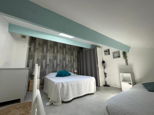 Un dormitorio con una cama con una almohada azul. en Pavillon climatisé 4 personnes 25m2, en Gruissan