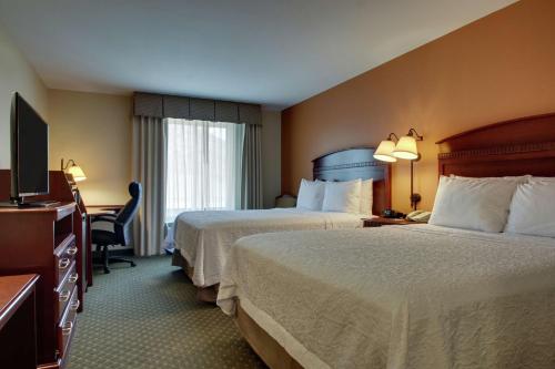 una camera d'albergo con due letti e una televisione di Hampton Inn & Suites Denver Littleton a Littleton