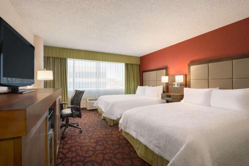 um quarto de hotel com duas camas e uma televisão de ecrã plano em Hampton Inn Denver West Federal Center em Lakewood