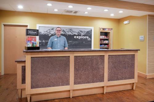 a man standing at a counter in a lobby at Hampton Inn and Suites Denver/South-RidgeGate in Lone Tree