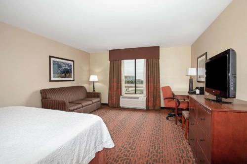 a hotel room with a bed and a flat screen tv at Hampton Inn and Suites Denver/South-RidgeGate in Lone Tree