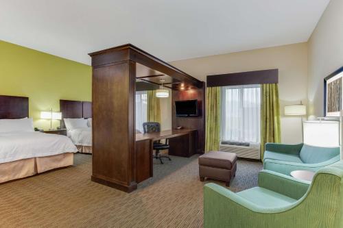 Cette chambre comprend un lit et un bureau. dans l'établissement Hampton Inn Ozark, à Ozark