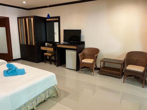 a bedroom with a bed and a desk and chairs at Summer Inn in Lamai