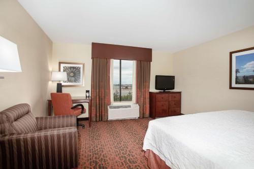 a hotel room with a bed and a desk and a television at Hampton Inn and Suites Denver/South-RidgeGate in Lone Tree