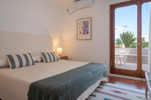 a bedroom with a bed with a view of a patio at Lanzarote Beach Apartments, CASA ONA in Costa Teguise