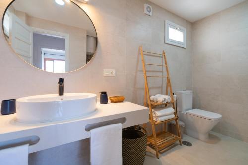 a bathroom with a sink and a mirror and a toilet at Lanzarote Beach Apartments, CASA ONA in Costa Teguise
