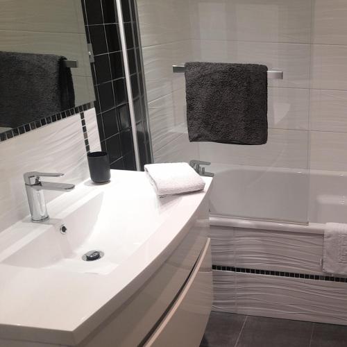 une salle de bain blanche avec un lavabo et une baignoire dans l'établissement Djo, à Moutiers