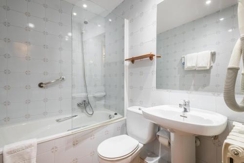 a bathroom with a toilet and a sink and a shower at Riu Nere Mountain Apartments in Vielha