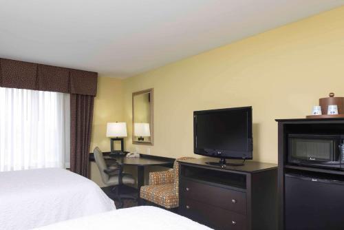 a hotel room with a bed and a flat screen tv at Hampton Inn & Suites Danville in Danville