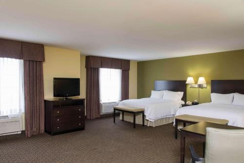 a hotel room with two beds and a flat screen tv at Hampton Inn & Suites Danville in Danville