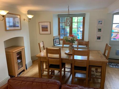 a dining room with a wooden table and chairs at Cosy cottage close to shops and pubs in Bishops Castle