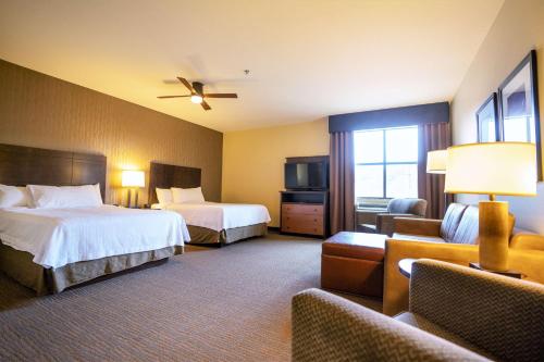 a hotel room with two beds and a couch at Homewood Suites by Hilton, Durango in Durango