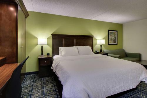 a hotel room with a large bed and a chair at Hampton Inn DuBois in DuBois