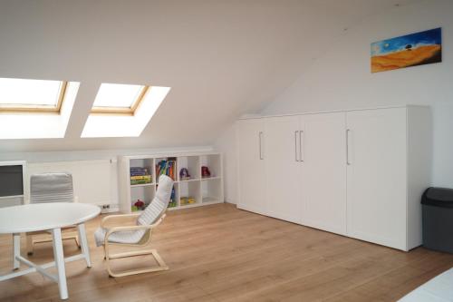 a room with a table and chairs and skylights at FeWo Vineta in Barth