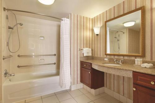 a bathroom with a tub shower and a sink at Homewood Suites by Hilton Detroit-Troy in Birmingham