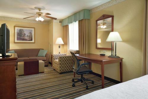 a hotel room with a desk and a bedroom at Homewood Suites by Hilton Detroit-Troy in Birmingham