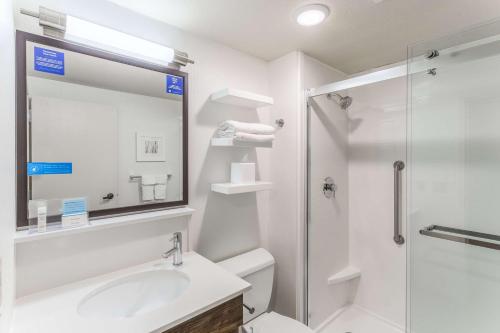 a white bathroom with a sink and a shower at Hampton Inn Eau Claire in Eau Claire