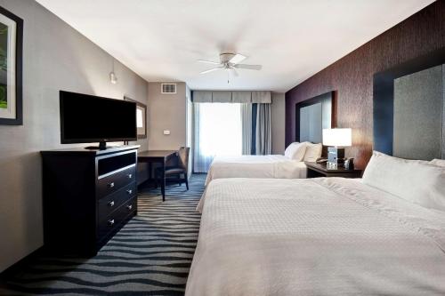 a hotel room with two beds and a flat screen tv at Homewood Suites By Hilton Dubois, Pa in DuBois