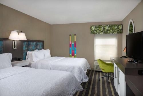 Habitación de hotel con 2 camas y TV de pantalla plana. en Hampton Inn Eagle Pass en Eagle Pass