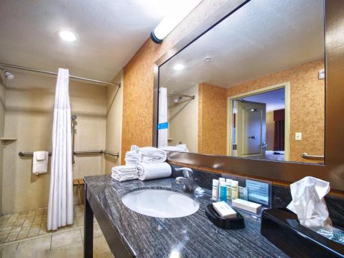 La salle de bains est pourvue d'un lavabo et d'un grand miroir. dans l'établissement Hampton Inn & Suites Elk City, à Elk City