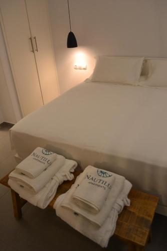 Una cama con toallas en una mesa junto a ella en Nautilus Apartments, en Lipsi