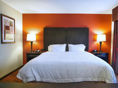 ein großes Bett in einem Hotelzimmer mit zwei Lampen in der Unterkunft Hampton Inn & Suites Elk City in Elk City