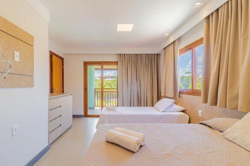a hotel room with two beds and a window at PF55 Ótima Casa 4 Suítes - Praia do Forte in Farol